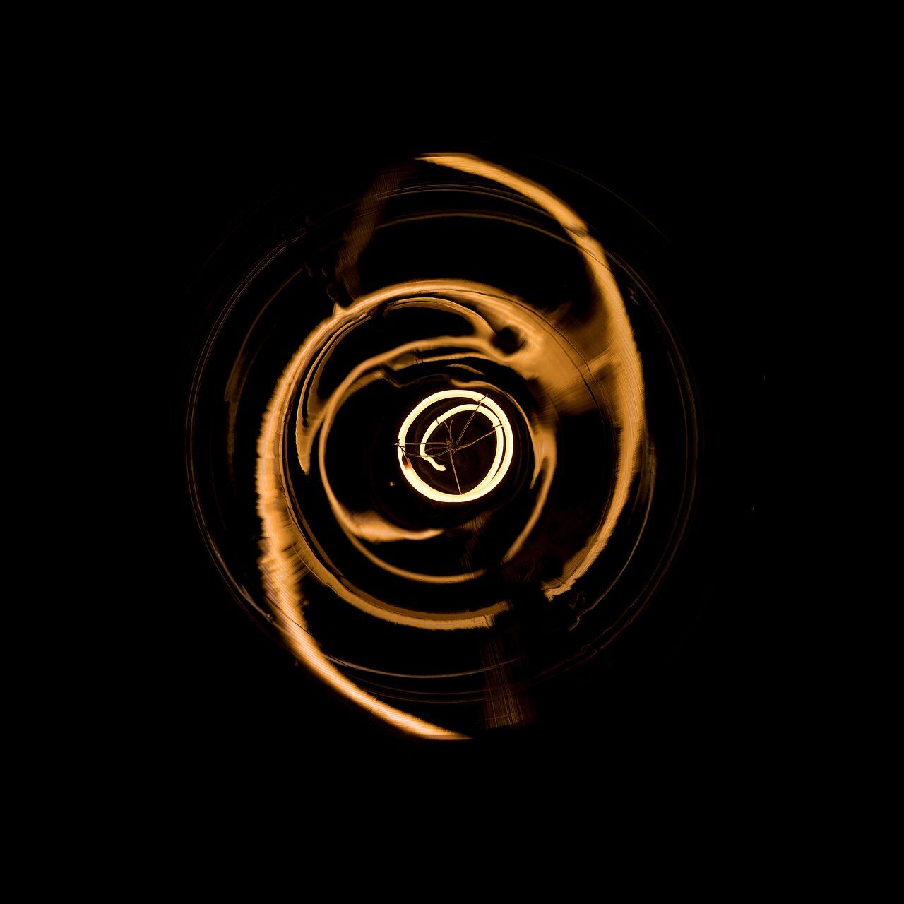 Glowing spiral filament bulb on a dark background